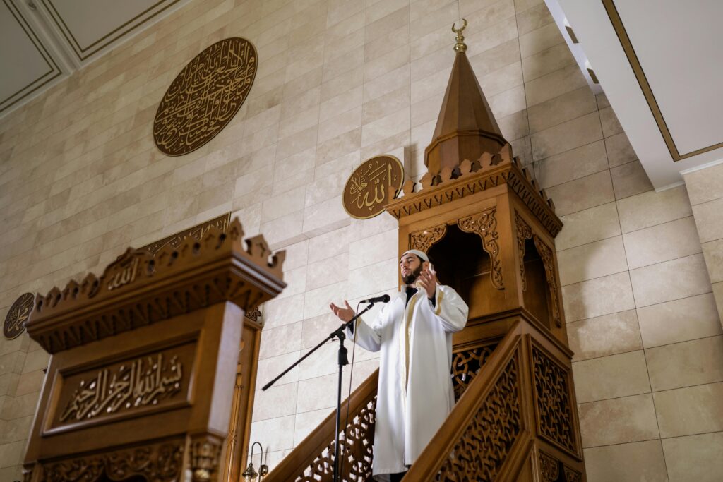 Imam delivers a sermon from a beautifully designed mosque minbar, symbolizing Islamic culture and faith.